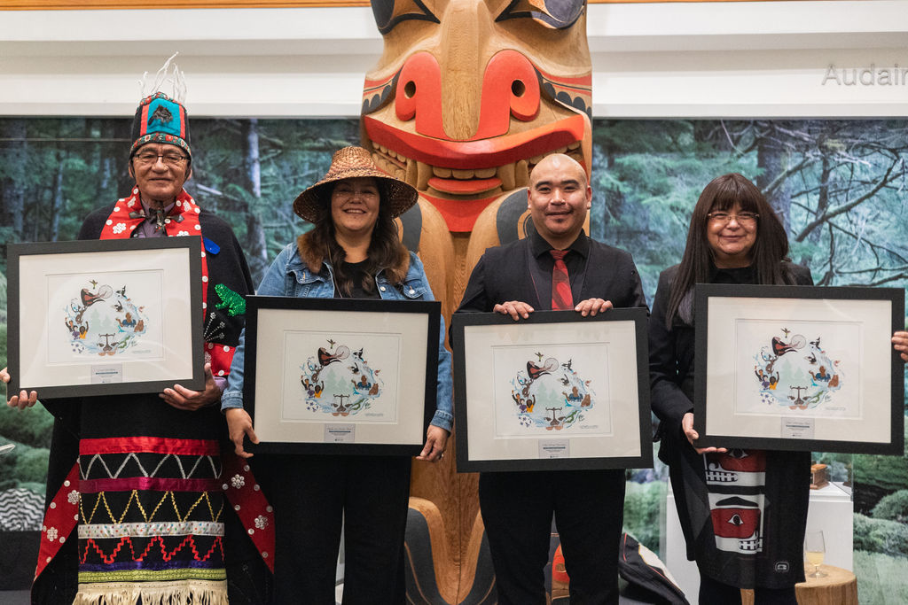 Four Indigenous leaders holding framed awards on stage